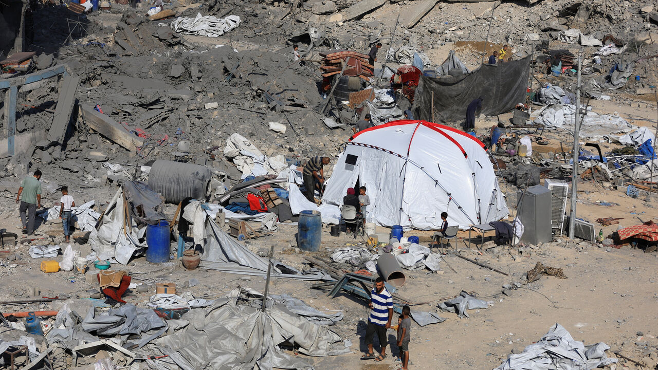 Palestinians inspect the site surrounding an evacuated UNRWA clinic where displaced people were taking shelter, following an overnight Israeli strike, in Gaza City August 6, 2025. REUTERS/Dawoud Abu Alkas