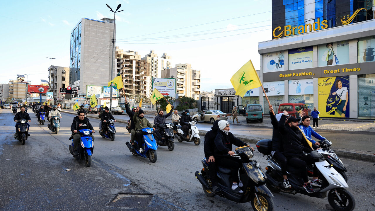 FILE PHOTO: Men carry Hezbollah flags while riding on two wheelers, at the entrance of Beirut's southern suburbs, in Lebanon, November 27, 2024. REUTERS/Thaier Al-Sudani/File Photo