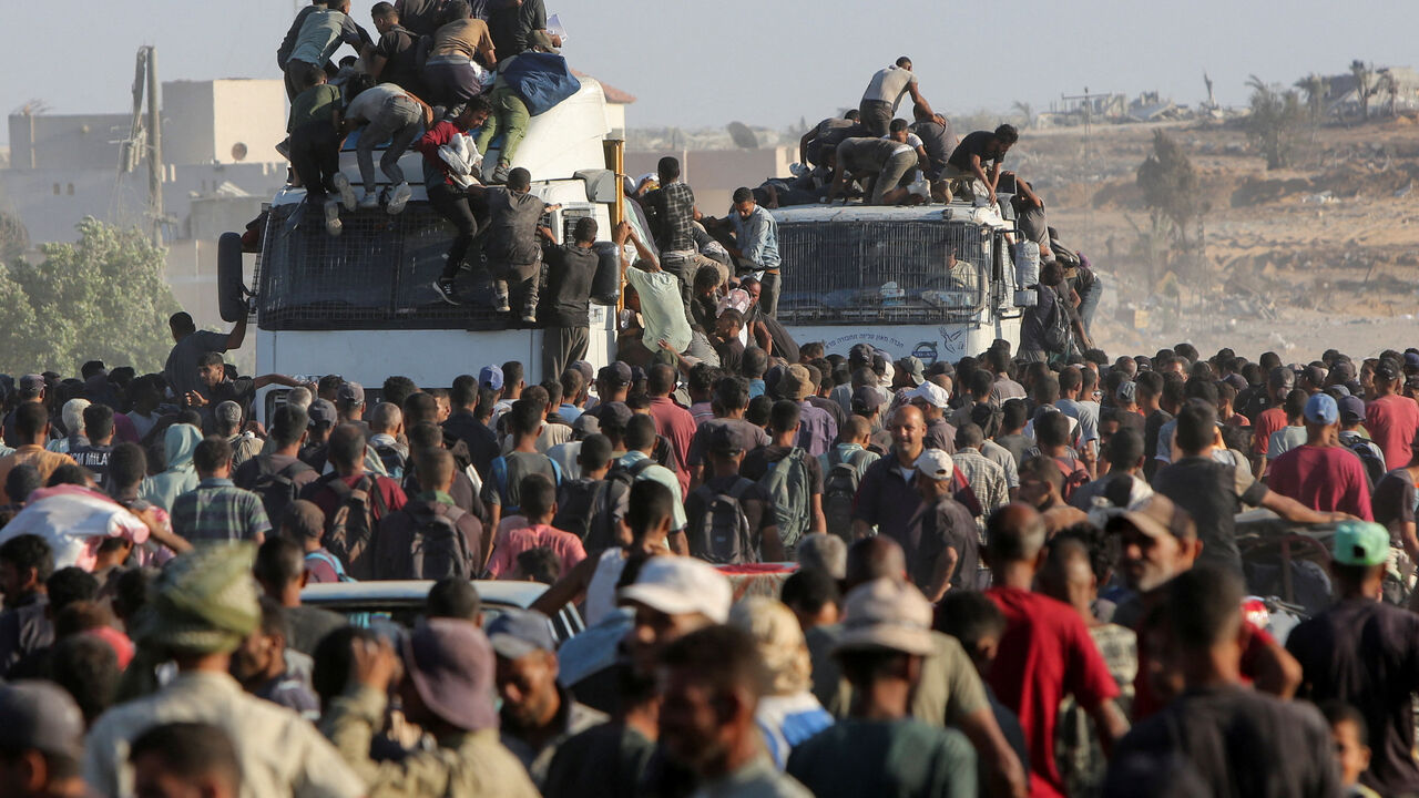 FILE PHOTO: Palestinians climb onto trucks as they seek aid supplies in Khan Younis, southern Gaza Strip, August 4, 2025. REUTERS/Hatem Khaled/File Photo