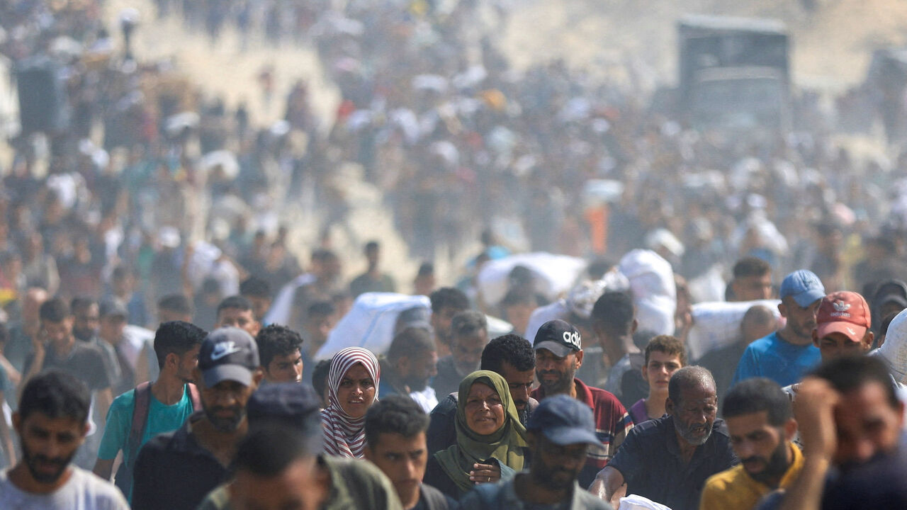 FILE PHOTO: Palestinians carry aid supplies they collected from trucks that entered Gaza through Israel, in Beit Lahia, in the northern Gaza Strip August 10, 2025. REUTERS/Dawoud Abu Alkas/File Photo