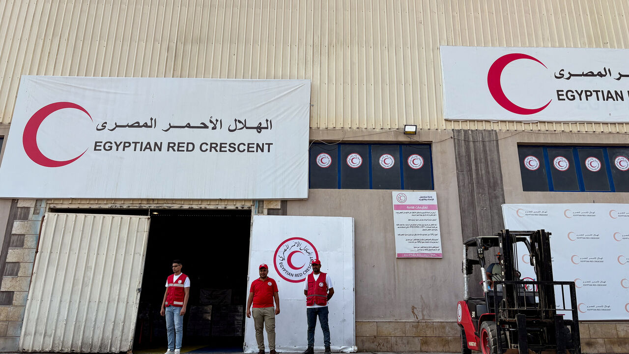People stand in front of a warehouse for aid deliveries, waiting to be delivered to Gaza, at a logistics site run by the Egyptian Red Crescent, outside Arish, Egypt, August 11, 2025. REUTERS/Alexander Dziadosz/File Photo