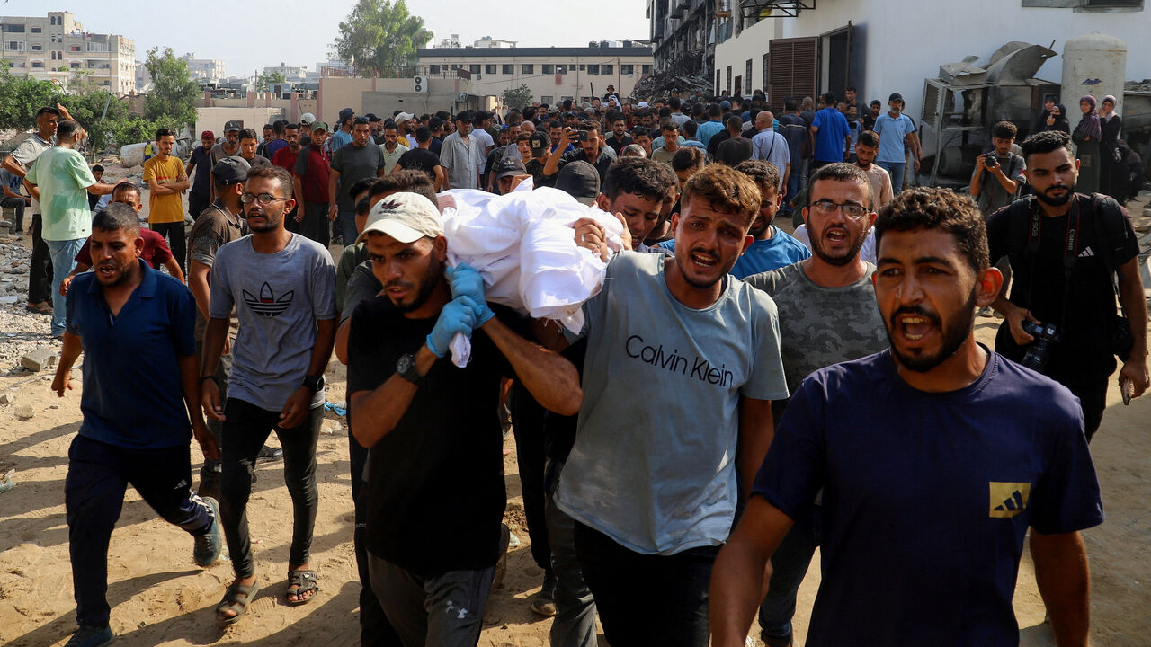 Mourners carry a body during the funeral of Palestinians killed in Israeli fire while seeking aid on Wednesday, according to medics, in Gaza City, August 14, 2025. REUTERS/Ebrahim Hajjaj