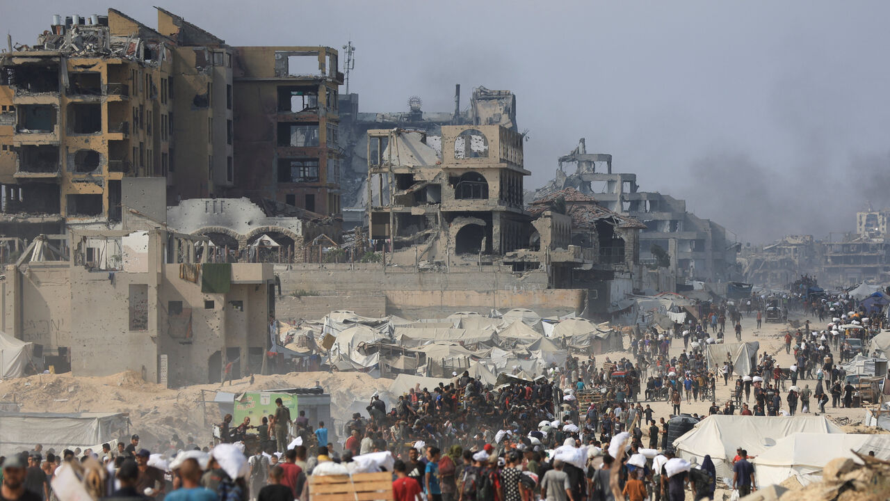 FILE PHOTO: Palestinians carry aid supplies they collected from trucks that entered Gaza through Israel, in Beit Lahia, in the northern Gaza Strip August 10, 2025. REUTERS/Dawoud Abu Alkas/File Photo