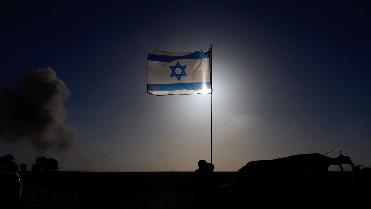 FILE PHOTO: An Israeli flag flies, near the Israel-Gaza border, amid the ongoing conflict between Israel and the Palestinian Islamist group Hamas, in Israel, March 4, 2024. REUTERS/Ammar Awad/File Photo