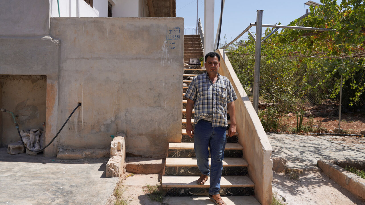 Abdelqader al-Sheikh, a neighbor who lives near the building, where according to Syrian security forces and residents, U.S. forces took part in a pre-dawn raid that targeted a member of the Islamic State group, a U.S. official and a Syrian security source said, walks outside his house, in Atmeh, Syria, August 20, 2025. REUTERS/Karam al-Masri