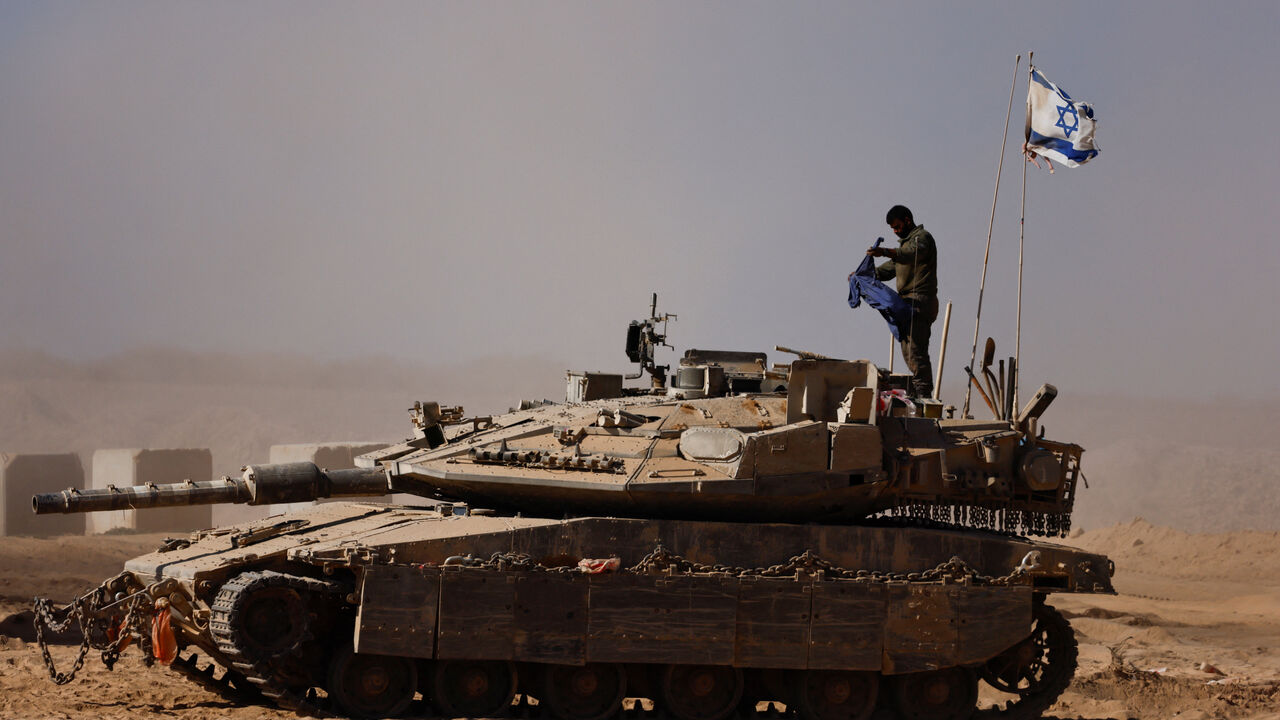 An Israeli soldier stands on a tank on the Israeli side of the border with Gaza, Israel August 20, 2025. REUTERS/Amir Cohen