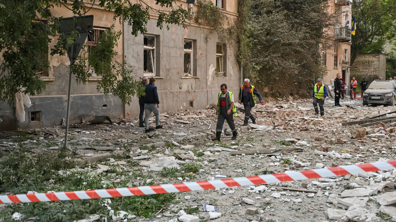 Communal workers pass by an apartment building hit by the Russian drone strike, amid Russia's attack on Ukraine, in Lviv, Ukraine August 21, 2025. REUTERS/Stringer