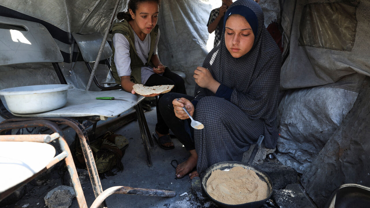 Sabrine Toushtash prepares dukkah for her children inside a tent shelter, amid food scarcity and a hunger crisis, in Gaza City, August 7, 2025. REUTERS/Dawoud Abu Alkas