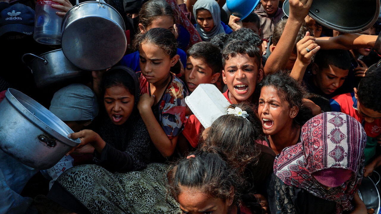 FILE PHOTO: Palestinians wait to receive food from a charity kitchen, in Khan Younis, southern Gaza Strip, August 21, 2025. REUTERS/Hatem Khaled/File Photo