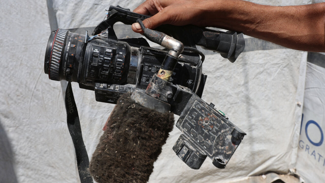 FILE PHOTO: Ezzeldin al-Masri holds equipment used by his brother Hussam al-Masri, the Reuters journalist killed by an Israeli strike on Monday while operating a live video feed at Gaza's Nasser Hospital, in Khan Younis, southern Gaza Strip, August 26, 2025. REUTERS/Ramadan Abed/File Photo
