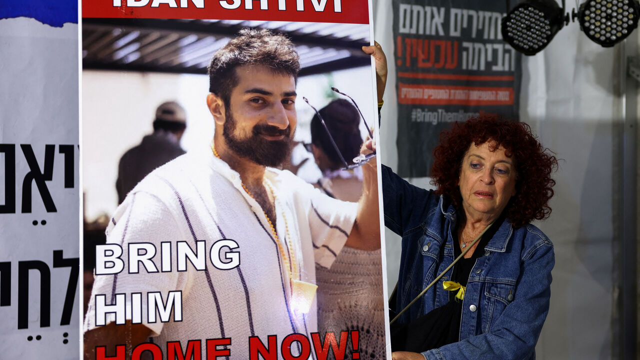 FILE PHOTO: A woman holds a poster with an image of Idan Shtivi, in Tel Aviv, Israel, as hostages are released by the Palestinian militant group Hamas, amid a hostages-prisoners swap deal between Hamas and Israel, November 26, 2023. REUTERS/Athit Perawongmetha/File photo