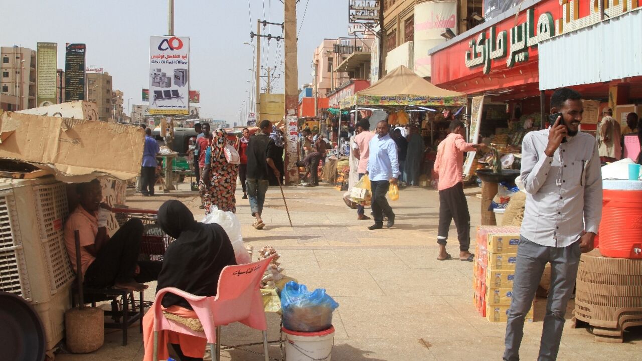 Sudanese walk past shops in Khartoum's twin city Omdurman on July 29, 2025
