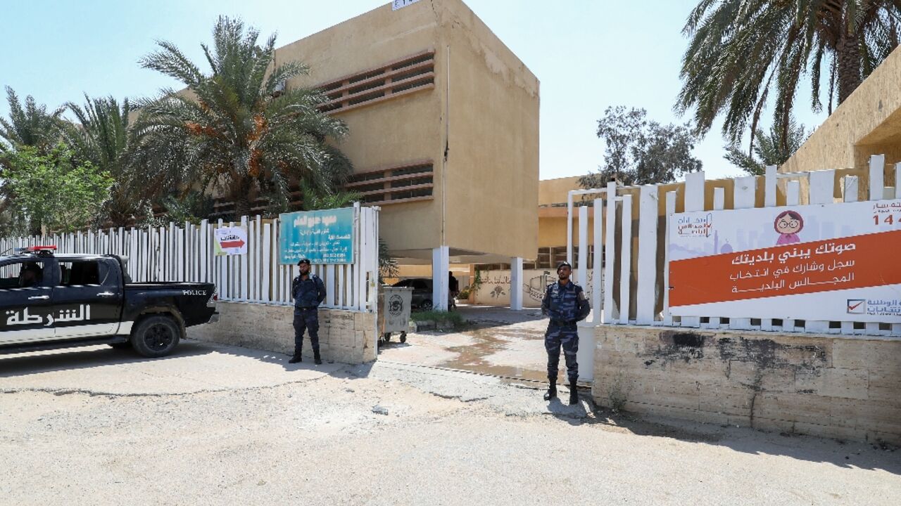 Libyan security officers stand guard outside a school in the capital Tripoli being used as a polling station in Saturday's municipal election.