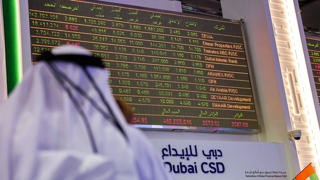 A man watches stock movements on a display at the Dubai Financial Market stock exchange, United Arab Emirates, April 12, 2022.