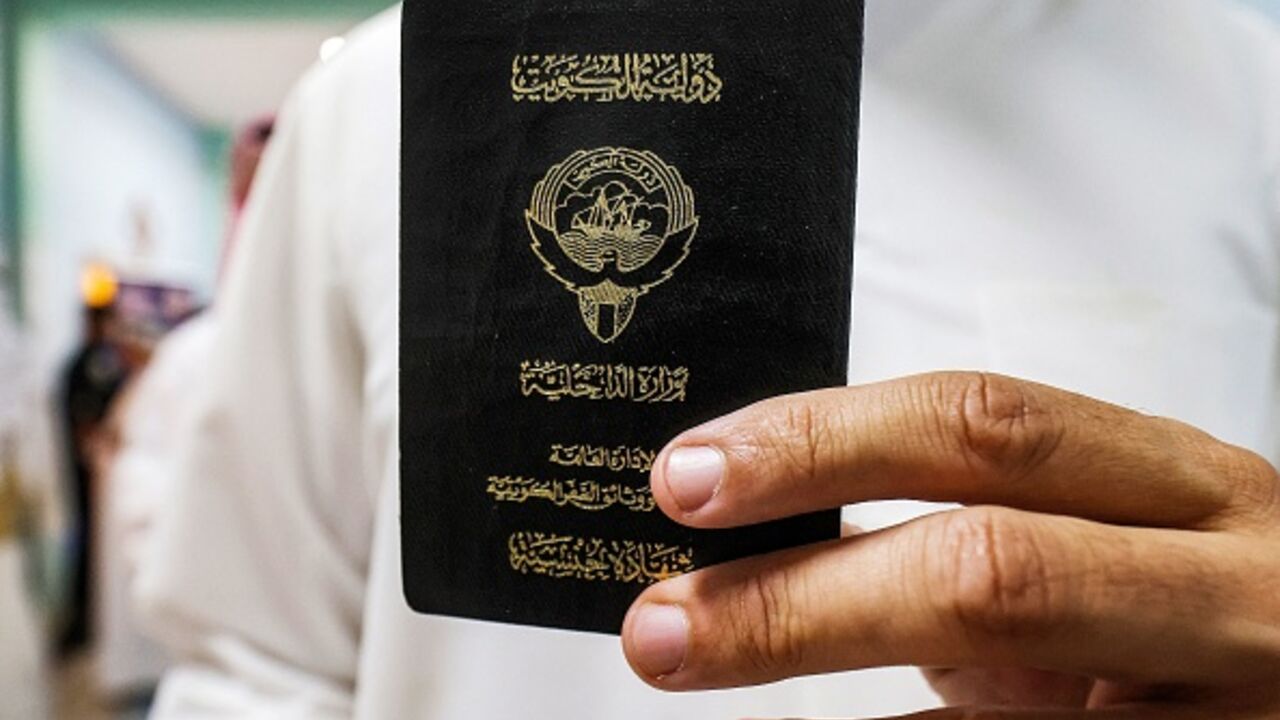 A voter holds his proof of Kuwaiti citizenship at a polling station during parliamentary elections in Kuwait City on June 6, 2023. (YASSER AL-ZAYYAT/AFP via Getty Images)