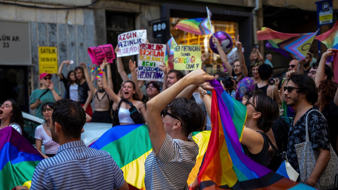 Protesters hold up placards and rainbow flags as they take part in the LGBTQ Pride March in Istanbul, June 25, 2023.