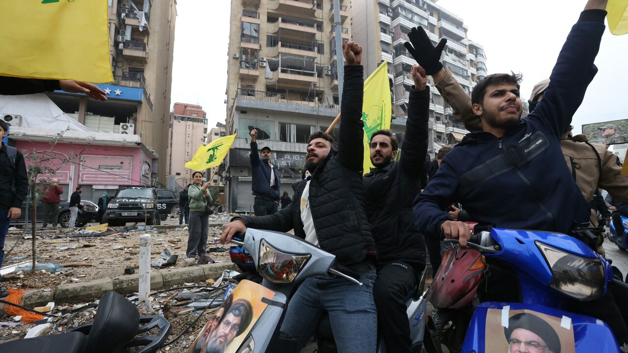Hezbollah supporters wave the yellow flag of the Lebanese militant group during a parade on motorbikes while people returned to the area to check their homes in Beirut's southern suburbs on Nov. 27, 2024, after a ceasefire between Israel and Hezbollah took effect. 
