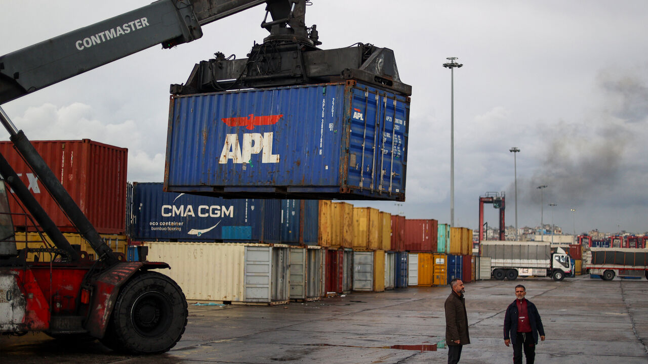 People unload containers at the port of Latakia in western Syria on Dec. 30, 2024. 