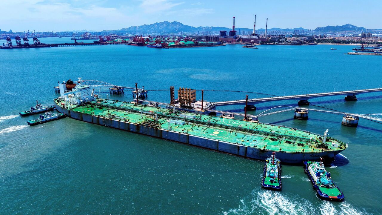 A ship loaded with oil docks at a pier with the help of a tugboat at the port of Qingdao, in eastern China's Shandong province on June 12, 2025. 
