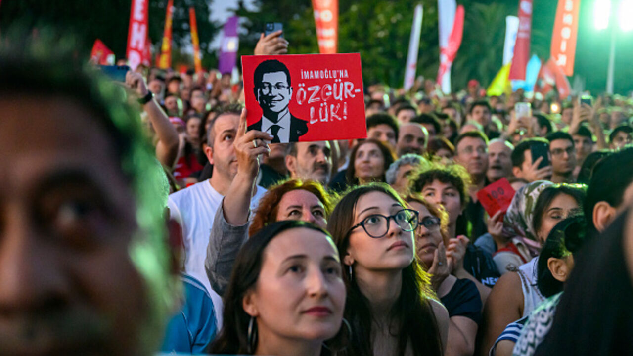 A protestor holds a placard of Istanbul's detained Mayor Ekrem Imamoglu as they listen to the leader of Turkey's main opposition Republican People's Party (CHP) Ozgur Ozel during a rally protesting the 100th day of his detention at Sarachane Square in Istanbul on July 1, 2025. (Photo by Yasin AKGUL / AFP) (Photo by YASIN AKGUL/AFP via Getty Images)