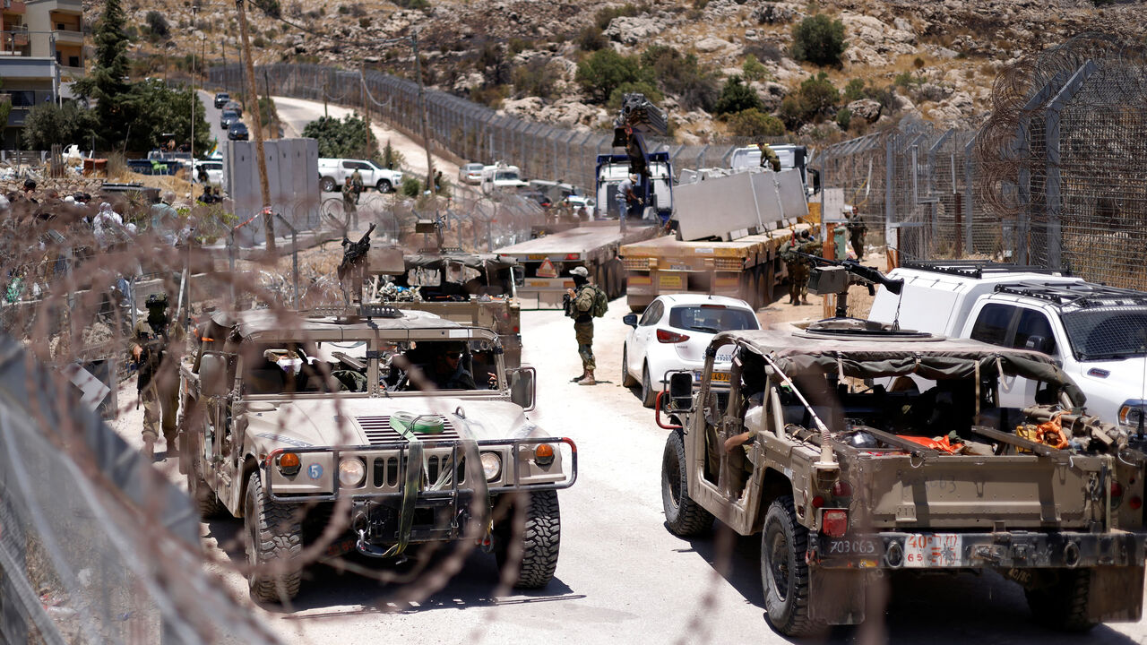 Israel military vehicles drive along the border fence into Israel, near the town of Majdal Shams, in the Israeli-annexed Golan Heights, July 17, 2025.