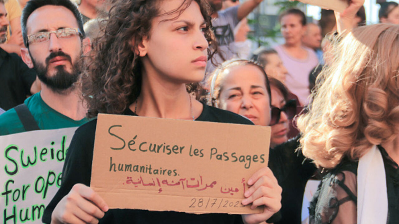 A Syrian carries a placard during protest of the humanitarian situation in the predominantly Druze city of Suweyda on July 28, 2025. (SHADI AL-DUBAISI/AFP via Getty Images)