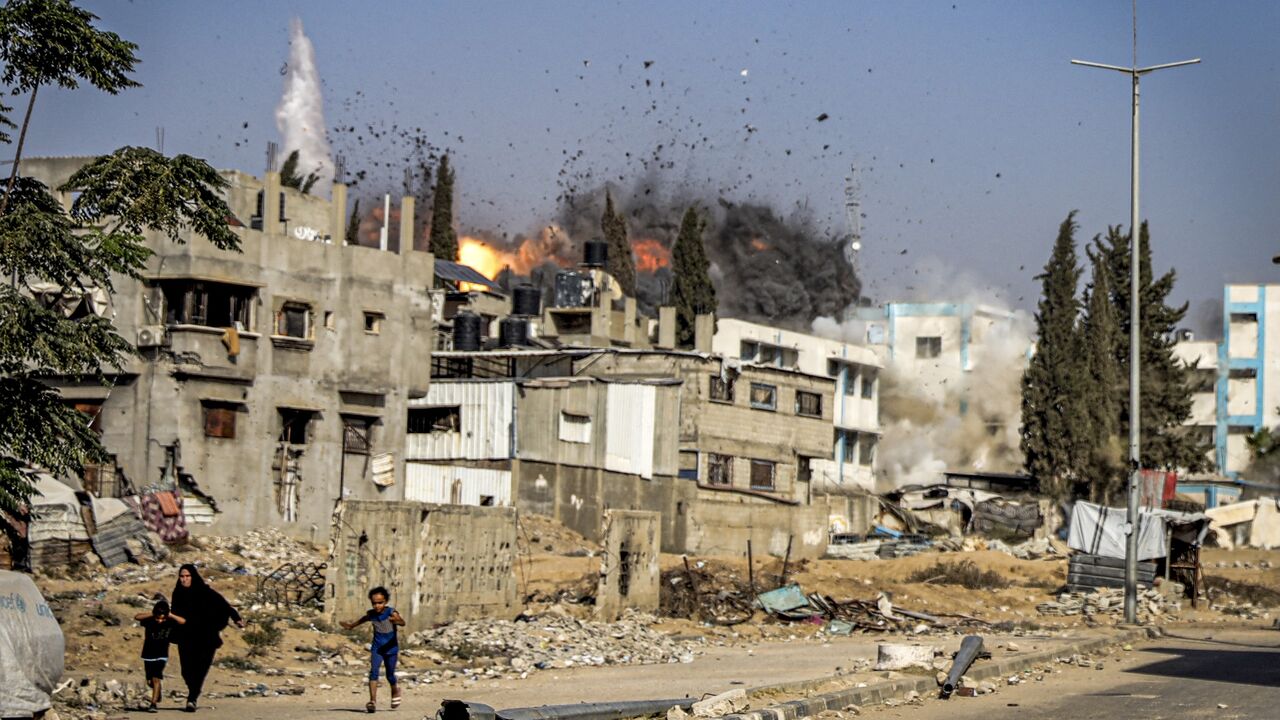 Palestinians run from an Israeli airstrike in Gaza City, July 18, 2025. 