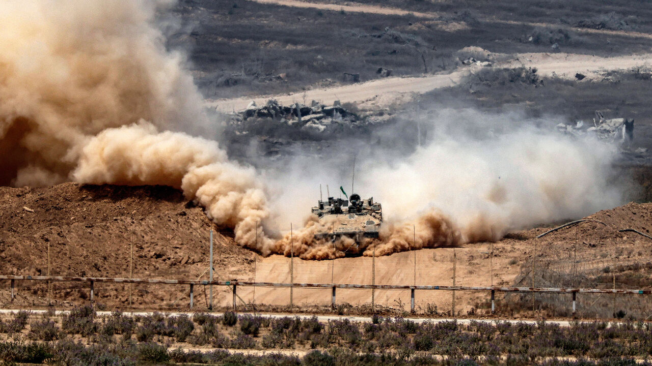 An Israeli army infantry-fighting vehicle leaves a cloud of dust as it moves at a position along Israel's southern border with the Gaza Strip, Aug. 5, 2025.