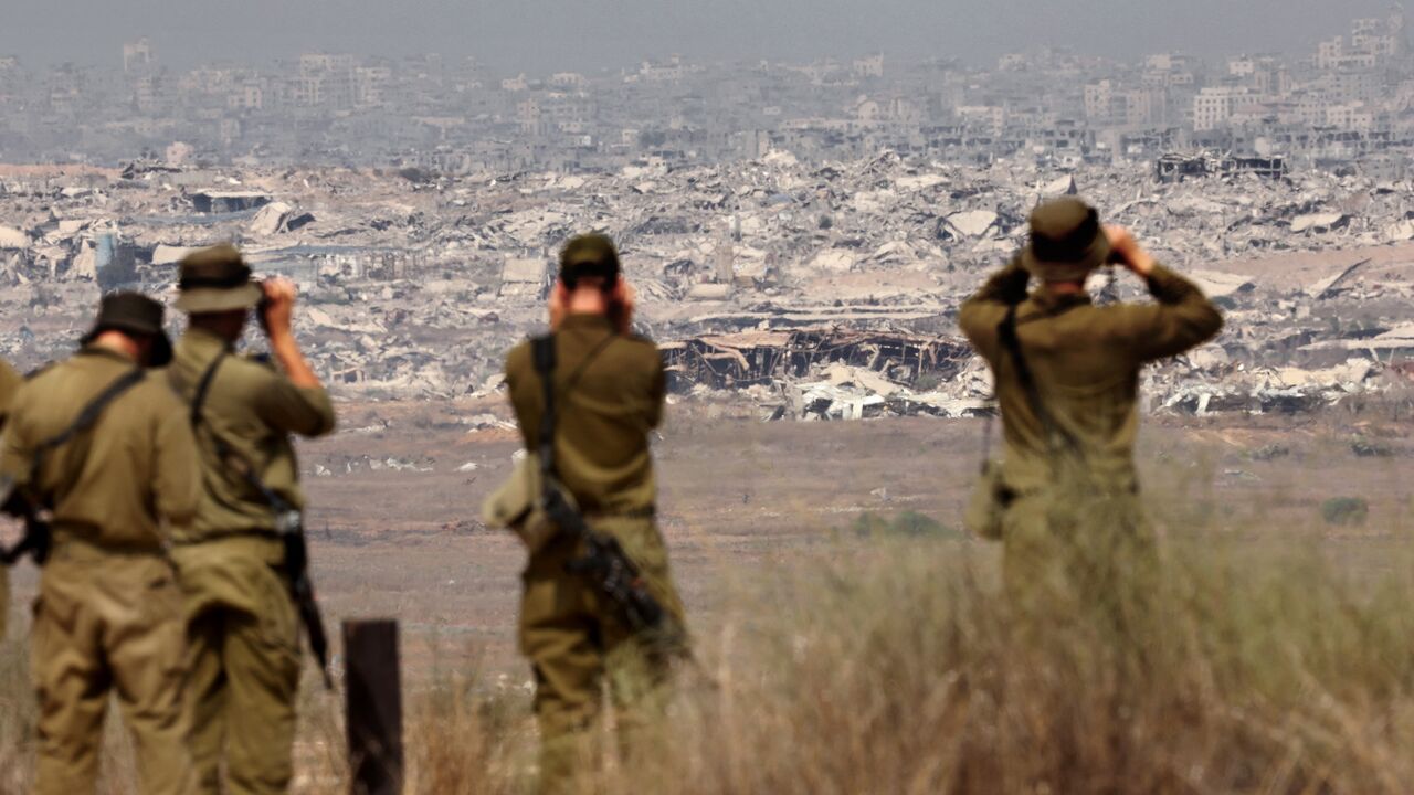 Israeli army soldiers look at the destruction in Gaza from the border with the Palestinian territory, Aug. 13, 2025.