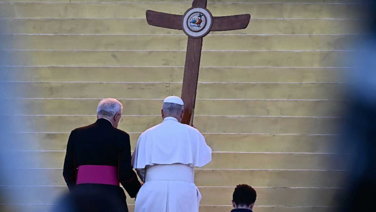 The pope took to the stage carrying a large wood cross