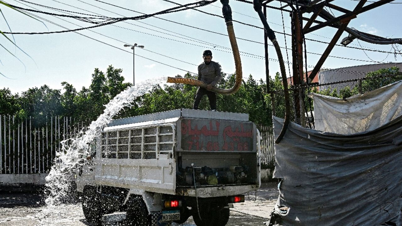 A man fills a delivery truck with water at a distribution facility in Beirut, where record-low rainfall is exacerbating pressure on the state water supply