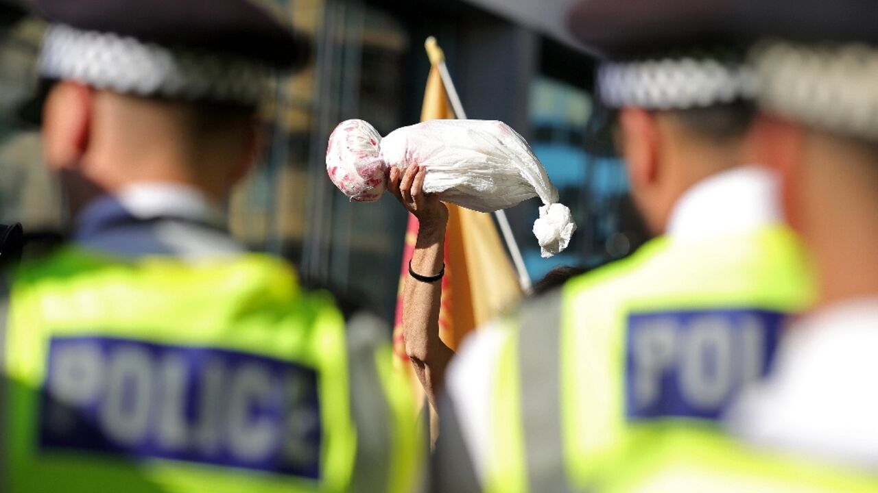 Police watched as around 300 protesters waved Palestinian flags and held up a placards