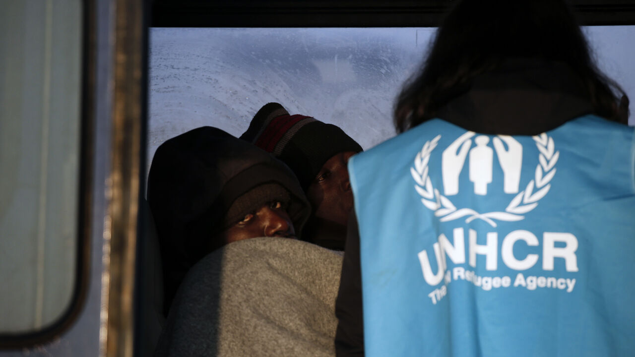 FILE PHOTO: A Congolese refugee looks on as a UNHCR volunteer checks on refugees and migrants rescued at open sea and waiting to be transferred to the Moria registration centre at the port of Mytilene on the Lesbos island, Greece March 21, 2016. REUTERS/Alkis Konstantinidis/File Photo