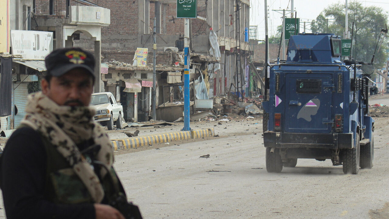 A police officer stands guard on a street with damaged shops in the background, following a militant attack on the Frontier Constabulary (FC) headquarters in Bannu, Khyber Pakhtunkhwa province, in Pakistan September 2, 2025. REUTERS/Ehsan Khattak