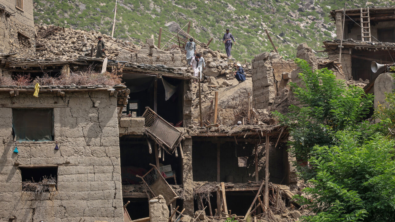 FILE PHOTO: Afghan men stand on top of a damaged house following a deadly magnitude-6 earthquake that struck Afghanistan on Sunday, in Mazar Dara, Kunar province, Afghanistan, September 2, 2025. REUTERS/Sayed Hassib/ File Photo