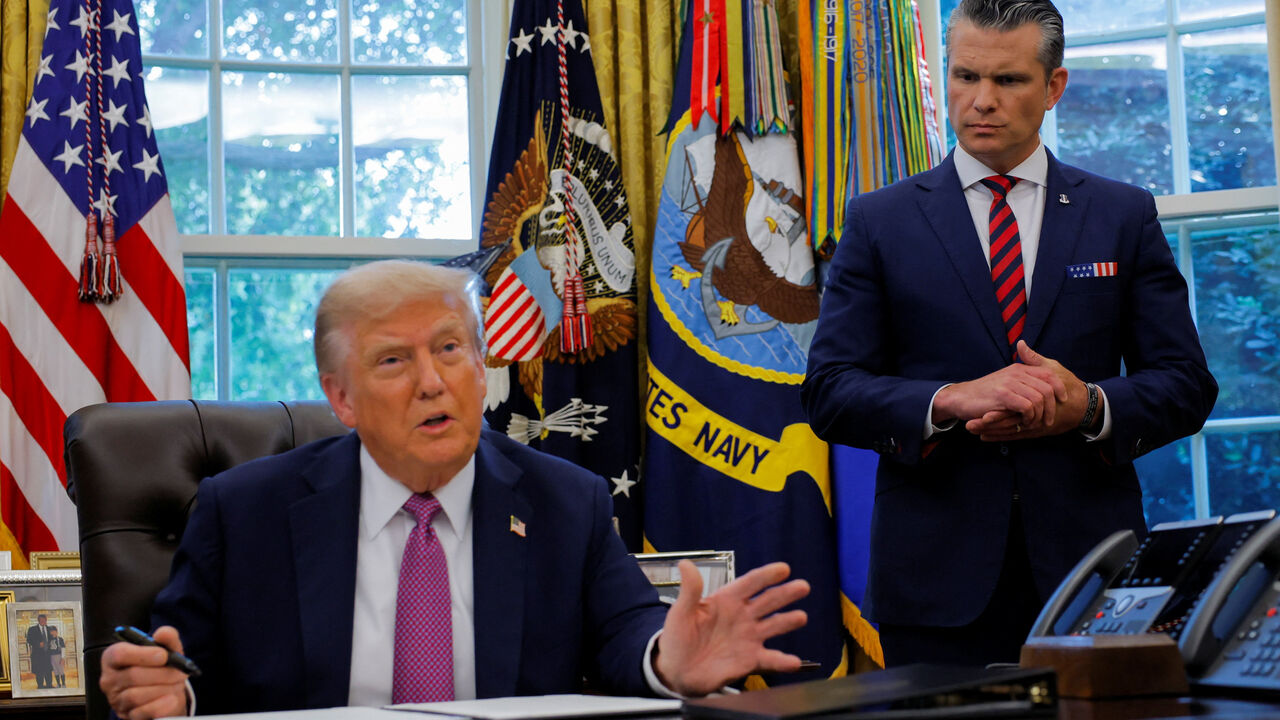 U.S. Defense Secretary Pete Hegseth listens as U.S. President Donald Trump speaks with the media while signing an executive order in the Oval Office, at the White House in Washington, D.C., U.S., September 5, 2025. REUTERS/Brian Snyder
