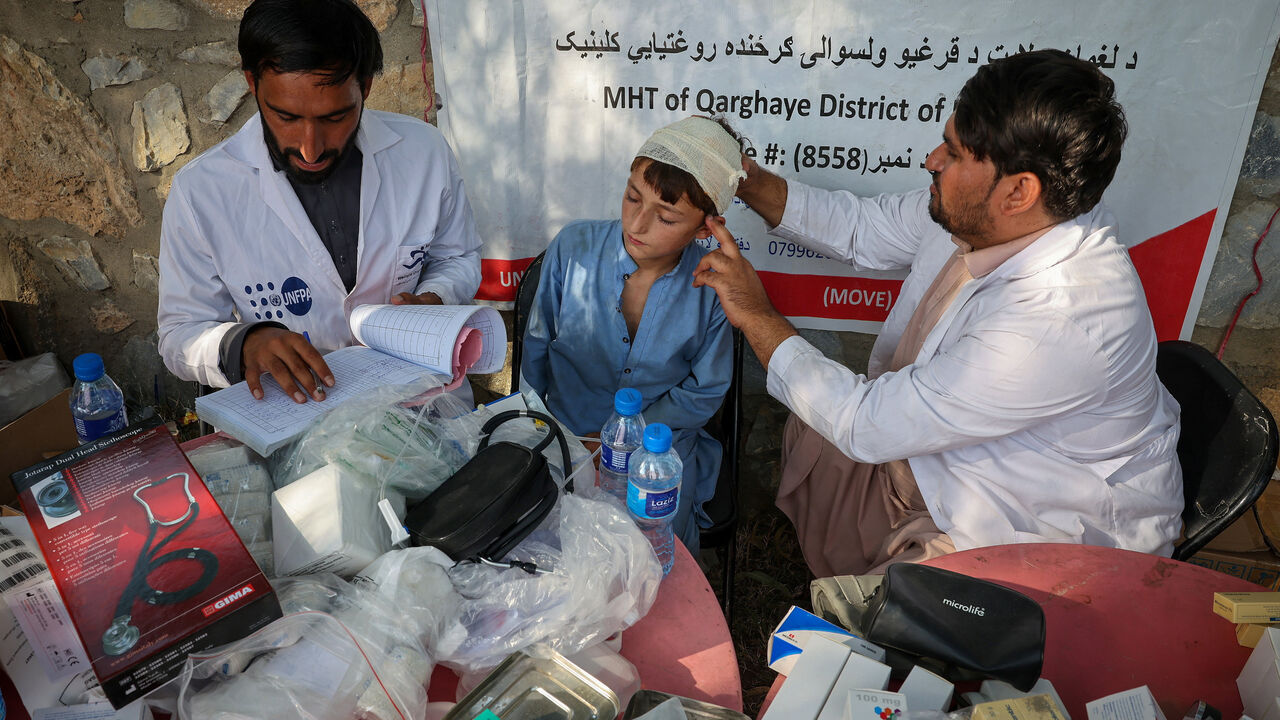 A doctor examines a victim of a deadly magnitude-6 earthquake that struck Afghanistan on Sunday, at a mobile clinic setup inside a school, in Nurgal district, Kunar province, Afghanistan, September 3, 2025. REUTERS/Sayed Hassib
