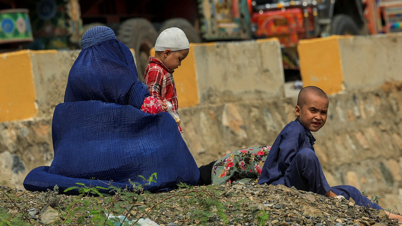 FILE PHOTO: An Afghan family rests, as they head back to Afghanistan after Pakistan started to deport documented Afghan refugees, near Torkham border crossing between Pakistan and Afghanistan, September 1, 2025. REUTERS/Fayaz Aziz/File Photo