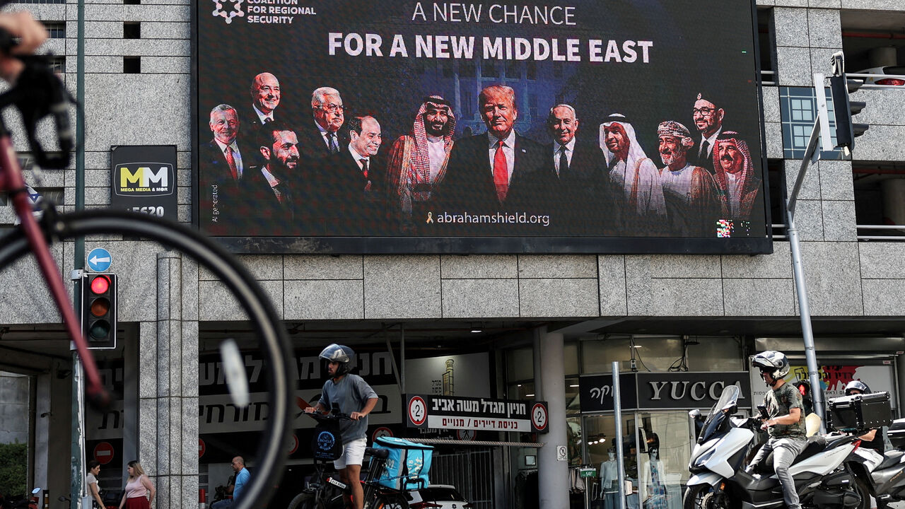 People walk by a billboard sponsored by the Coalition for Regional Security calling for the expansion of the Abraham Accords, in Ramat Gan, Israel June 26, 2025 REUTERS/Violeta Santos Moura/File Photo