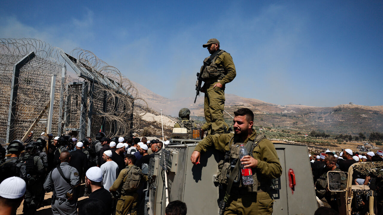 FILE PHOTO: Members of Israeli security forces stand at the ceasefire line between the Israeli-occupied Golan Heights and Syria, July 16, 2025. REUTERS/Ammar Awad/File Photo