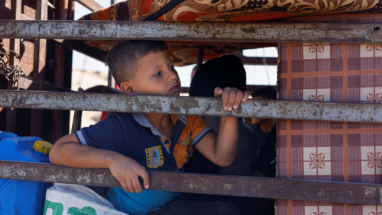 A child, part of crowds of displaced Palestinians fleeing northern Gaza due to an Israeli military operation, rides southward in a vehicle packed with personal belongings, after Israeli forces ordered residents of Gaza City to evacuate to the south, in the central Gaza Strip, September 21, 2025. REUTERS/Mahmoud Issa
