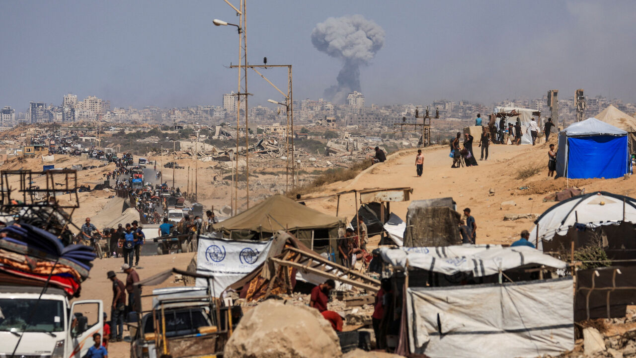 Smoke rises from an Israeli strike, as displaced Palestinians, fleeing northern Gaza due to an Israeli military operation, move southward after Israeli forces ordered residents of Gaza City to evacuate to the south, in the central Gaza Strip September 22, 2025. REUTERS/Dawoud Abu Alkas