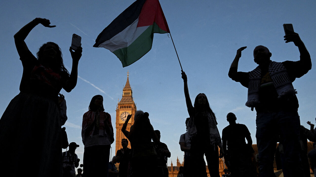FILE PHOTO: A woman holds a Palestinian flag as demonstrators attend a rally organised by Defend Our Juries, challenging the British government's proscription of "Palestine Action" under anti-terrorism laws, in Parliament Square, in London, Britain, August 9, 2025. REUTERS/Jaimi Joy/ File Photo