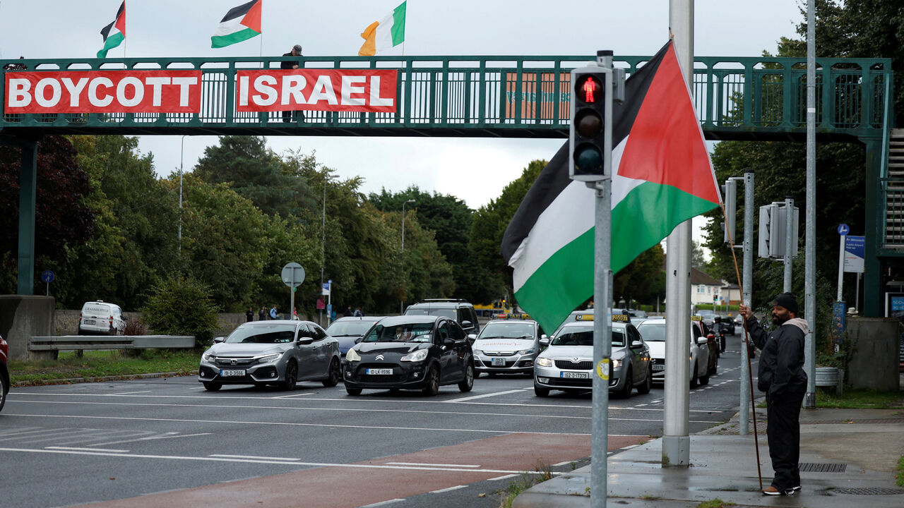 FILE PHOTO: Pro-Palestinian protestors hold flags and a sign on a motorway overpass outside the RTE (Radio Telefis Eireann) Irish public service broadcaster television studios, in Dublin, Ireland, September 11, 2025. REUTERS/Clodagh Kilcoyne/File Photo