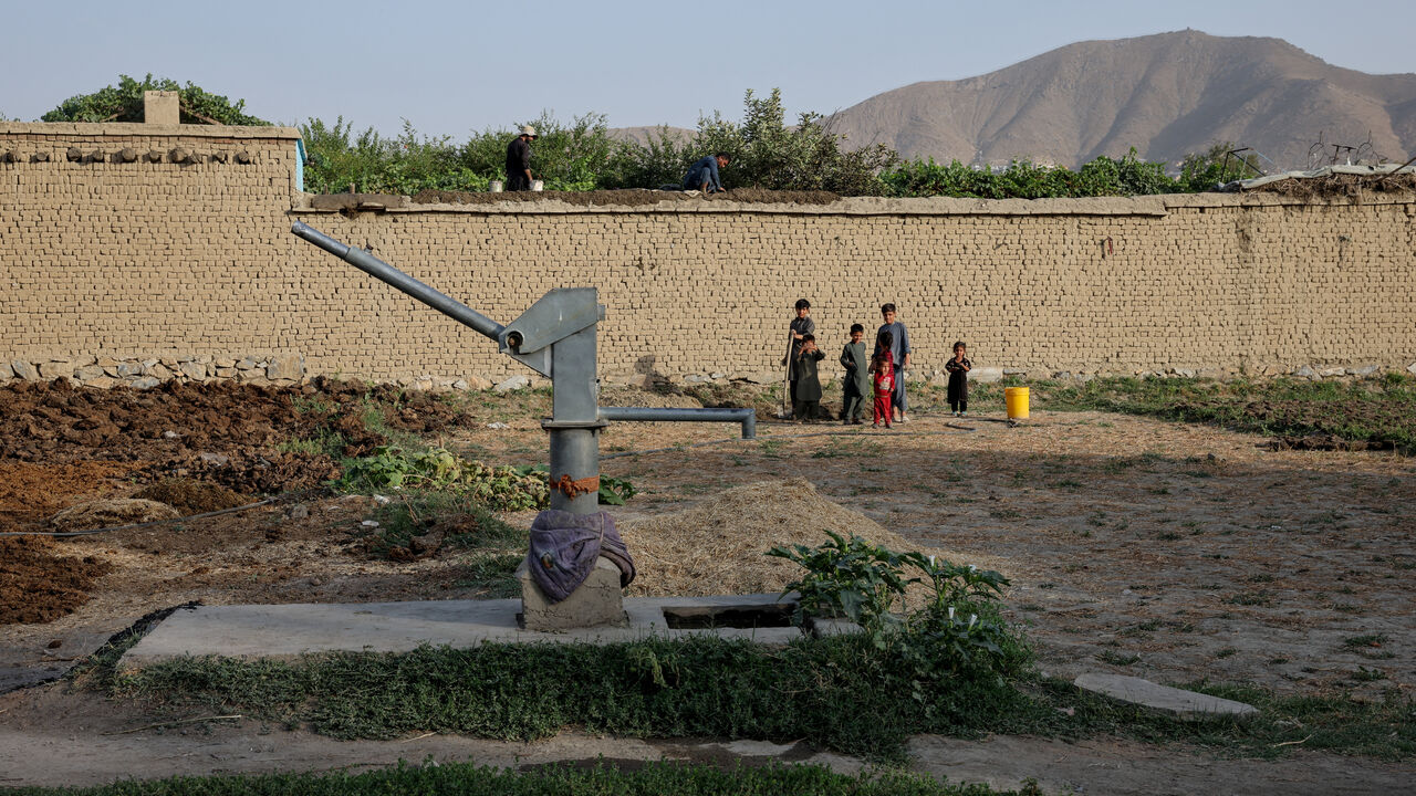 Children stand nearby a dried-up hand-pump, amid serious water crisis in Kabul, Afghanistan, August 29, 2025. REUTERS/Sayed Hassib