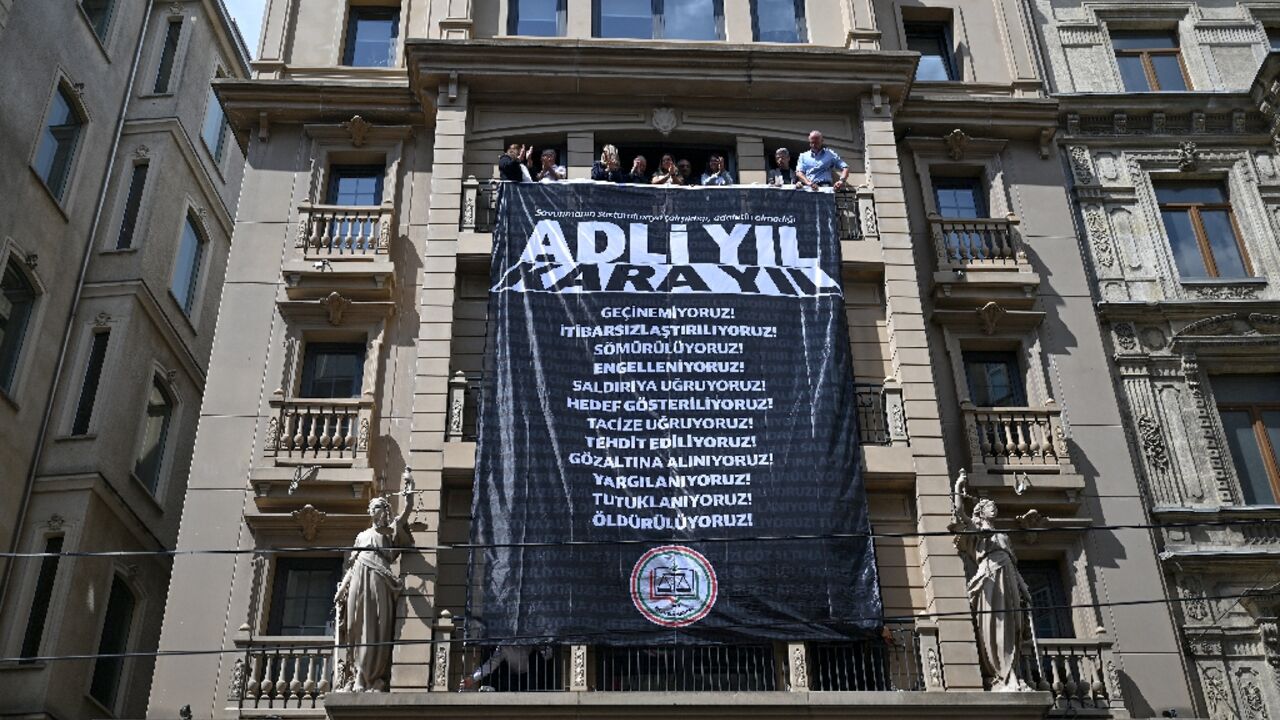 Lawyers in crossfire: Istanbul Bar Association members unfurl a protest banner at their HQ