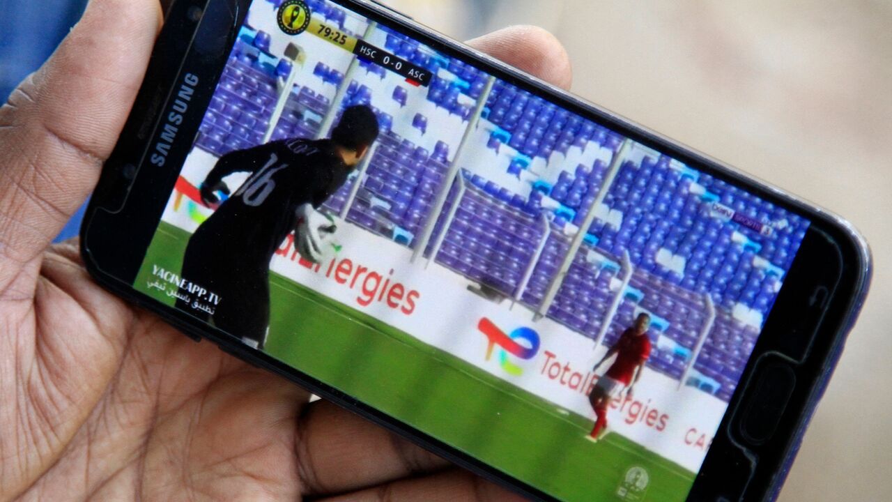 A supporter of Sudanese football team al-Hilal Omdurman watches on a phone a stream of his team's CAF Champions League group stage match.