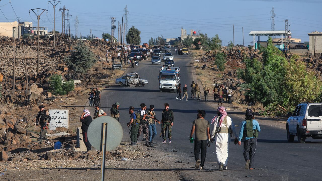 Bedouin and tribal fighters deploy at the western entrance of Syria's Druze heartland of Suwayda on July 18, 2025. 