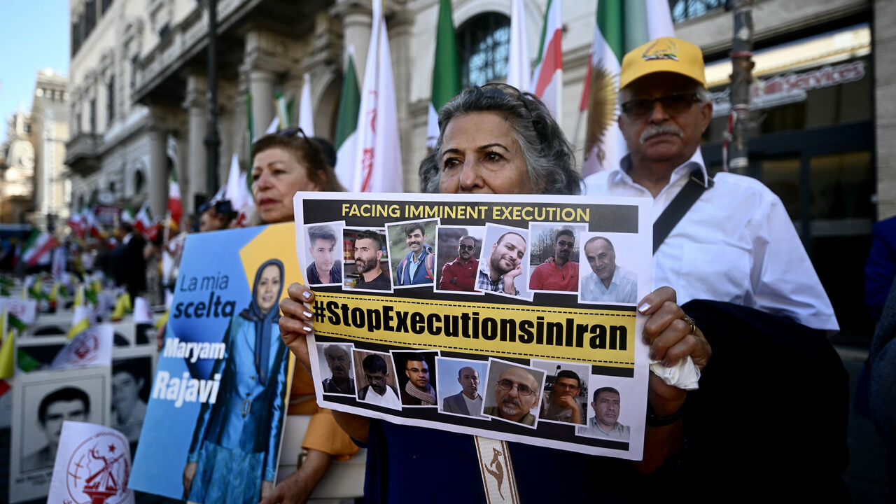 Protesters hold placard against executions in Iran during a rally against the Iranian regime in Rome on July 30, 2025. 