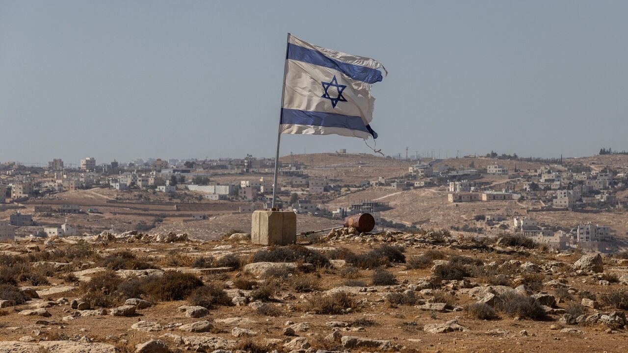 An Israeli flag flies along a highway near the settlement of Carmel on Aug. 4, 2025, in the South Hebron Hills of the West Bank. 